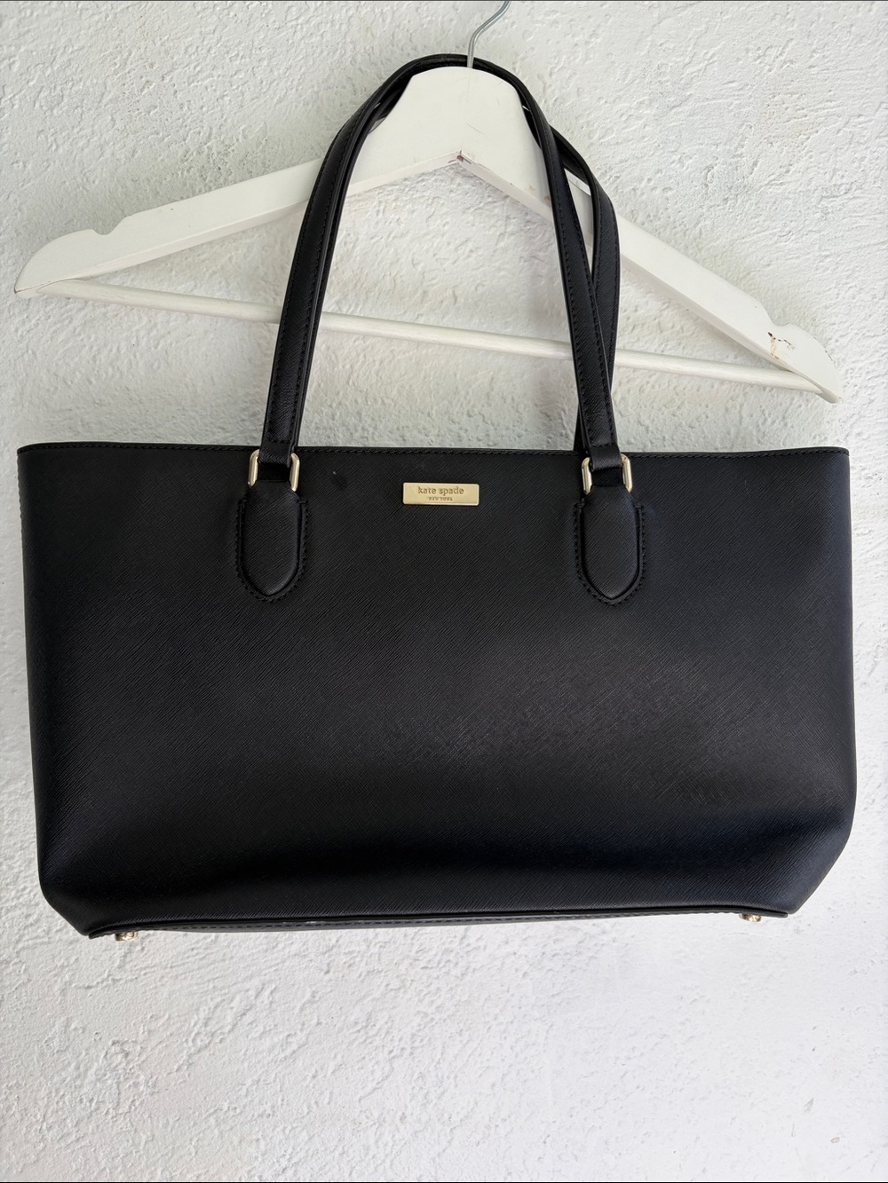 kate spade black leather tote with gold-tone plaque